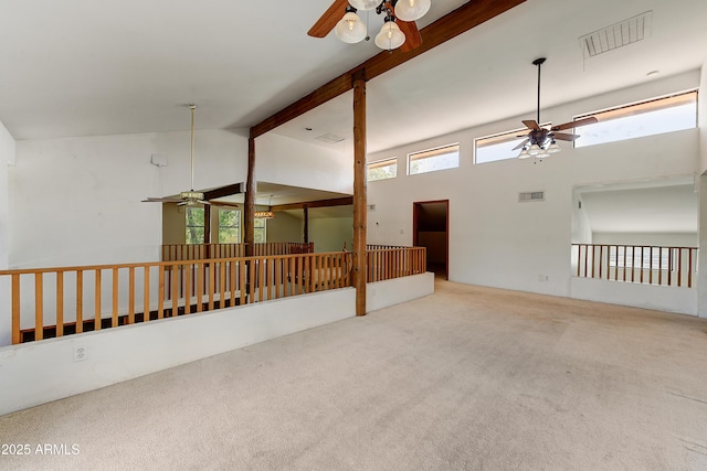 unfurnished room featuring beamed ceiling, carpet flooring, a ceiling fan, and visible vents