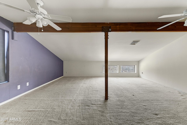 interior space featuring visible vents, carpet flooring, baseboards, ceiling fan, and vaulted ceiling with beams