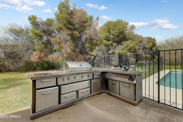 view of patio featuring an outdoor pool, area for grilling, an outdoor kitchen, and fence