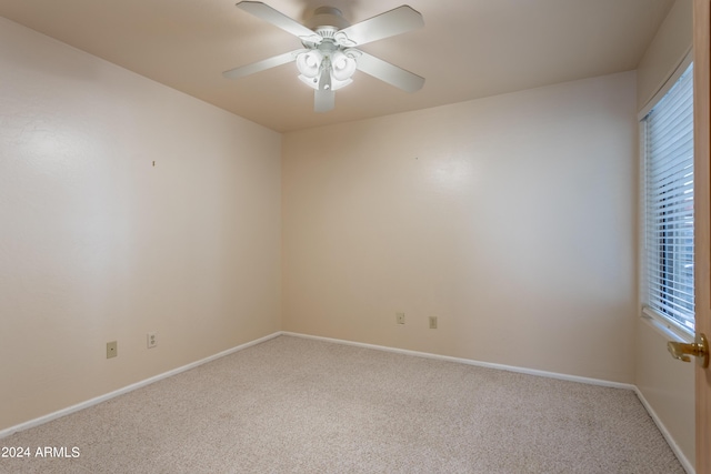 carpeted spare room featuring ceiling fan and a healthy amount of sunlight