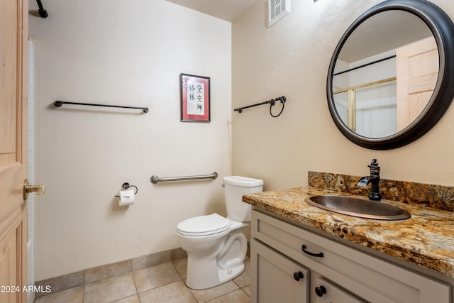 bathroom with toilet, tile patterned flooring, and vanity