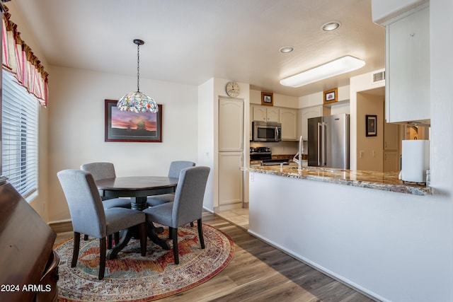 dining area with light wood-type flooring and sink