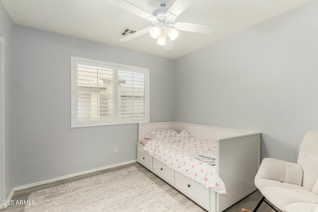 bedroom featuring a ceiling fan, light wood-type flooring, visible vents, and baseboards