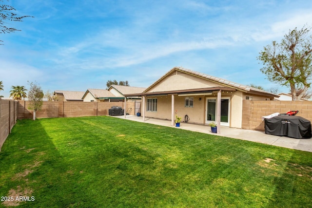 back of house featuring a patio area, a fenced backyard, a lawn, and stucco siding