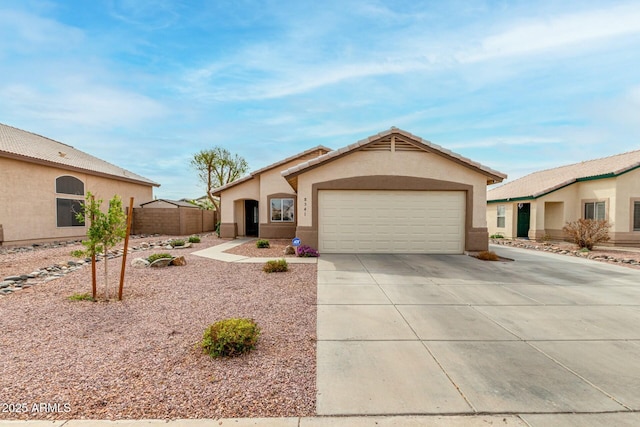 view of front facade featuring a garage, driveway, fence, and stucco siding