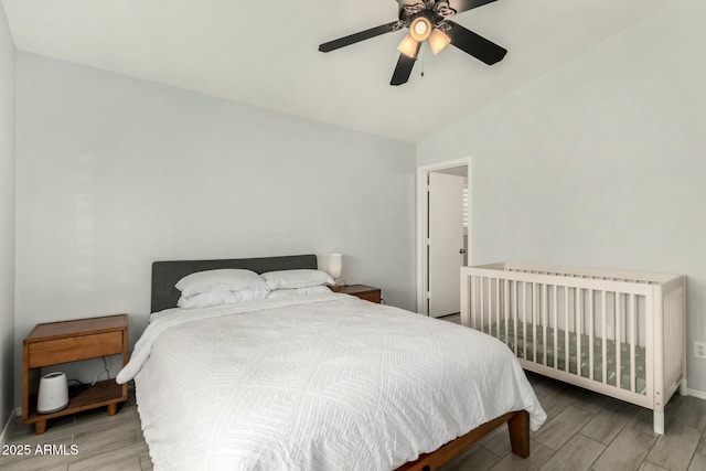 bedroom with baseboards, vaulted ceiling, a ceiling fan, and wood finish floors