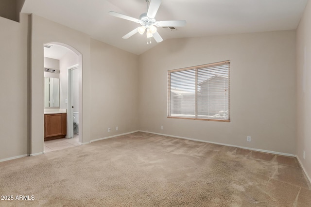 9243 W Brown St, Peoria, AZ 85345 - spare room featuring light carpet, arched walkways, a ceiling fan, vaulted ceiling, and baseboards