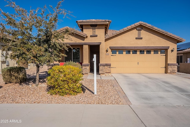 view of front of property with stucco siding, concrete driveway, a garage, stone siding, and a tiled roof