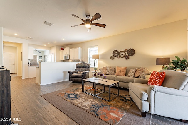 living room with ceiling fan and dark hardwood / wood-style flooring