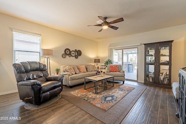 living area featuring a ceiling fan, dark wood-style flooring, and baseboards