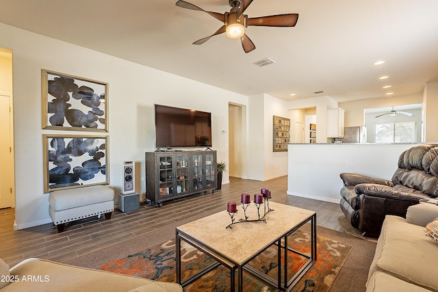 living room featuring dark wood-type flooring and ceiling fan