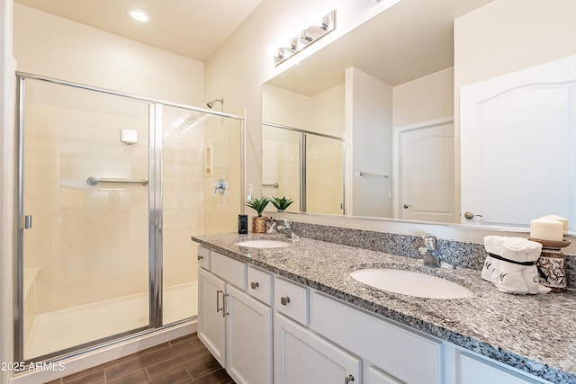 bathroom featuring a stall shower, wood tiled floor, and a sink