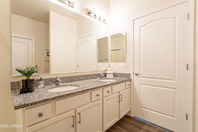 bathroom featuring a sink, wood finish floors, and double vanity