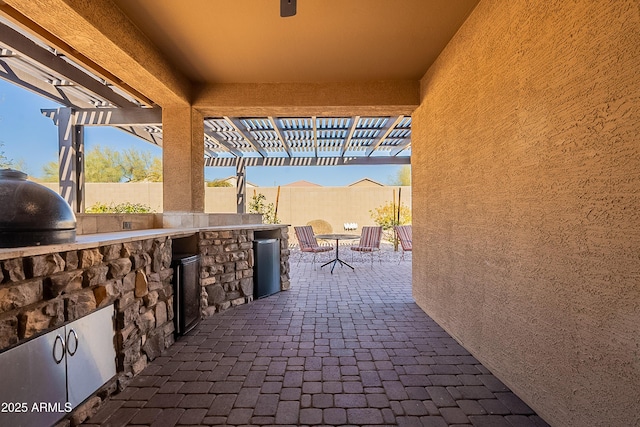 view of patio / terrace featuring grilling area, a fenced backyard, outdoor dining space, and exterior kitchen