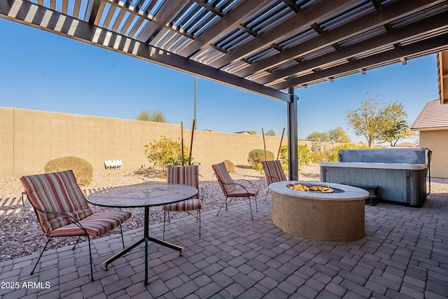 view of patio / terrace with a hot tub, a pergola, and a fire pit