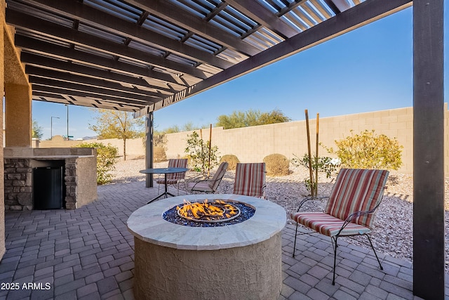 view of patio featuring an outdoor kitchen, a fenced backyard, a pergola, and an outdoor fire pit