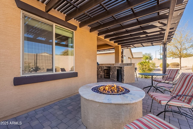 view of patio / terrace featuring an outdoor kitchen and a fire pit