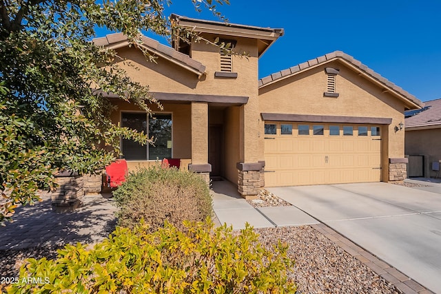 view of front of home with stucco siding, a tiled roof, concrete driveway, and a garage