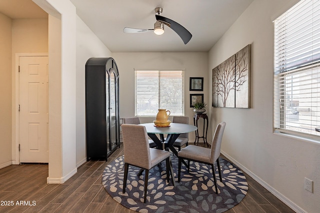 dining space featuring a ceiling fan, baseboards, and wood tiled floor