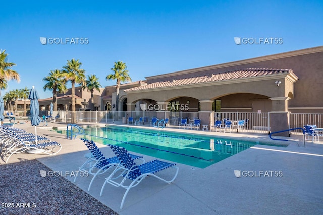 pool with a patio area and fence