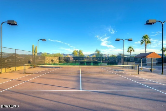 view of tennis court with basketball hoop