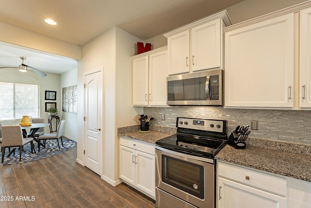 kitchen with dark stone countertops, white cabinets, and appliances with stainless steel finishes