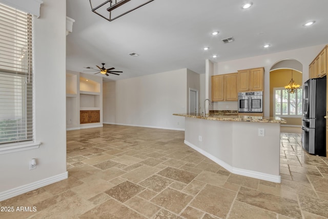 kitchen featuring stainless steel appliances, baseboards, recessed lighting, and stone tile flooring