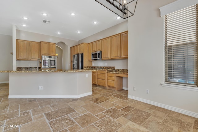 kitchen with arched walkways, visible vents, stainless steel appliances, and stone tile floors