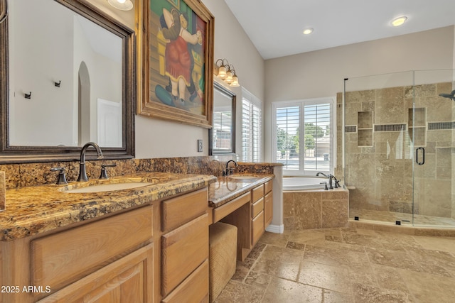 bathroom featuring stone tile flooring, a sink, a bath, and a shower stall