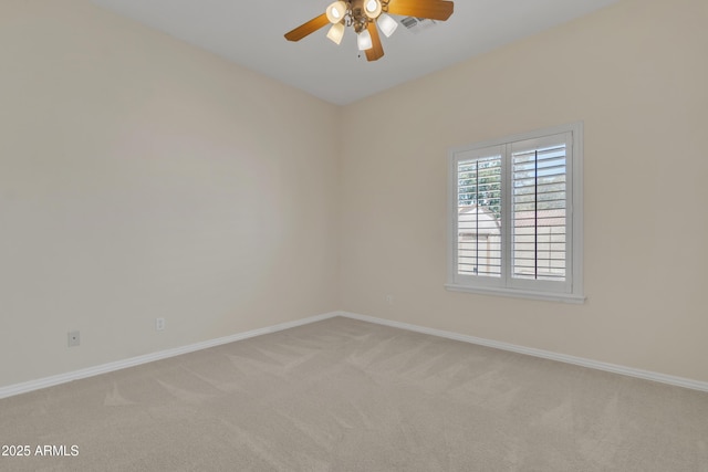 empty room featuring light colored carpet, a ceiling fan, and baseboards