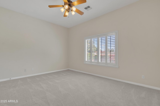 empty room with ceiling fan, light colored carpet, and baseboards