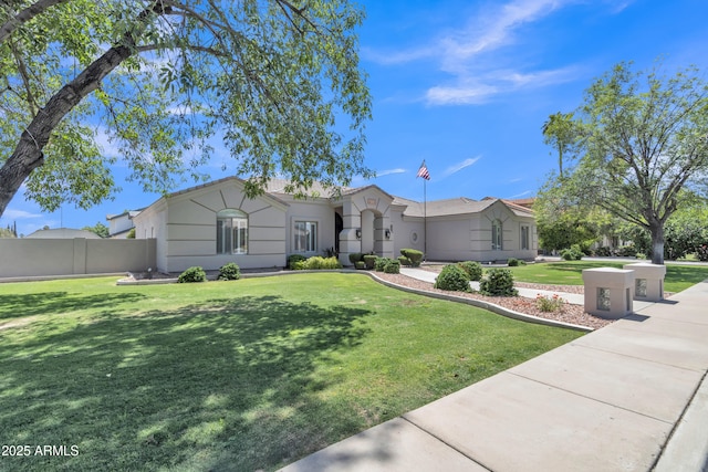 ranch-style home featuring fence, stucco siding, and a front lawn