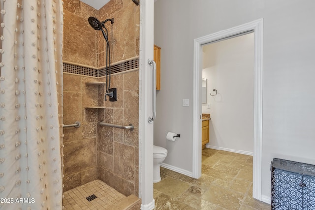 full bath featuring vanity, toilet, baseboards, a shower stall, and stone tile flooring