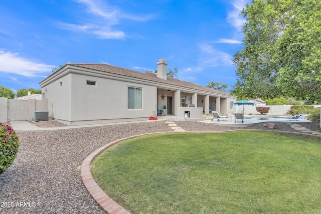 rear view of house with a lawn, a patio area, central air condition unit, a fenced backyard, and stucco siding
