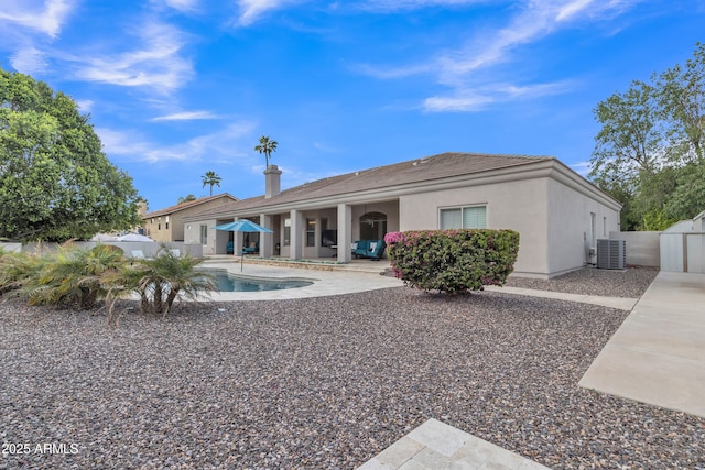 back of property featuring central AC, stucco siding, a fenced in pool, a patio area, and a tiled roof