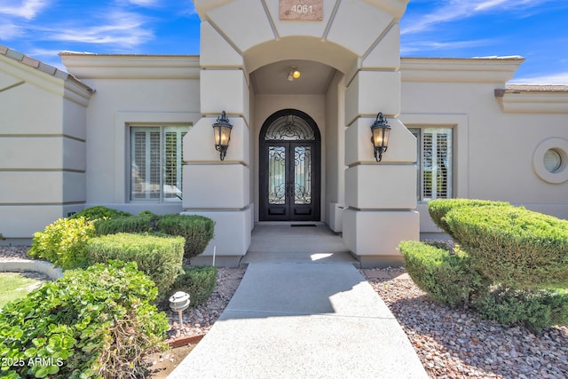 property entrance with stucco siding and french doors