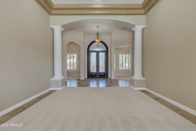 carpeted entryway with visible vents, arched walkways, and baseboards