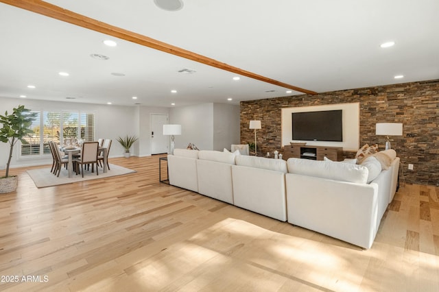 living room with light hardwood / wood-style flooring and beamed ceiling