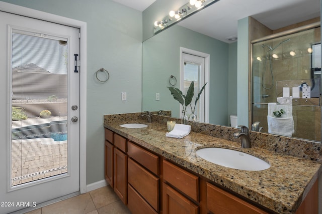 bathroom with toilet, a shower with door, vanity, and tile patterned floors