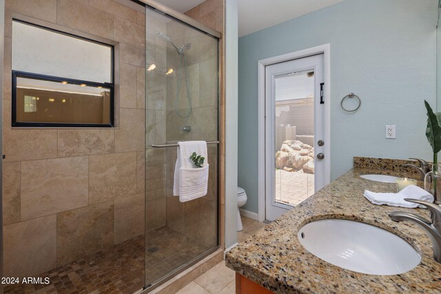 bathroom with toilet, a shower with shower door, tile patterned floors, and vanity