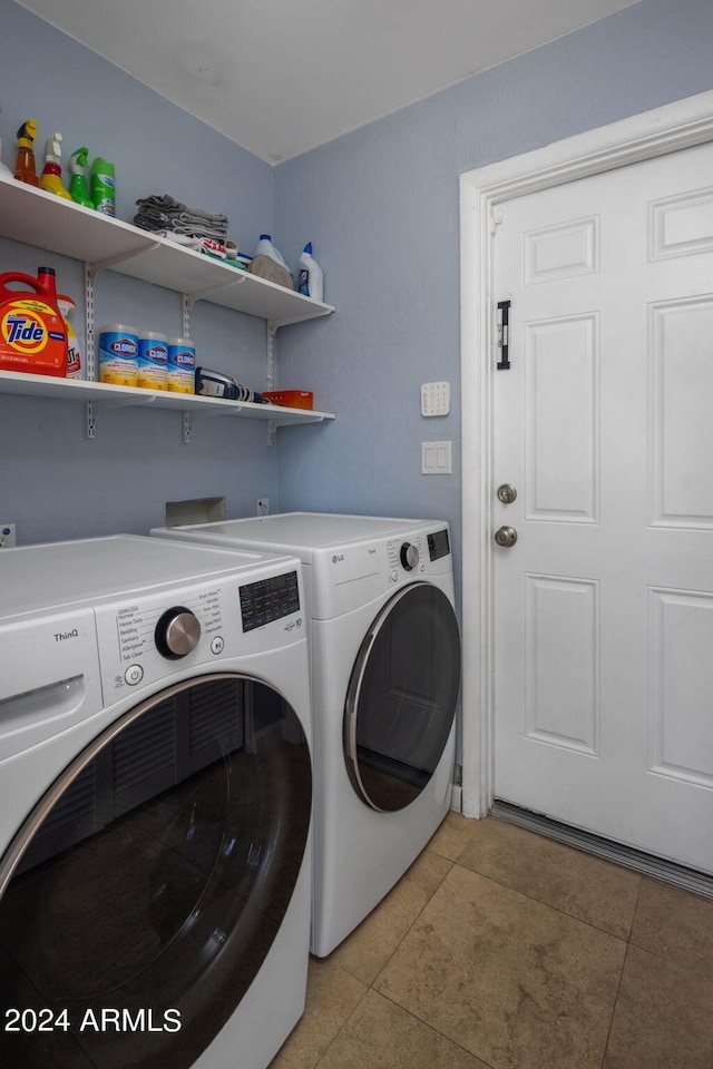 clothes washing area with light tile patterned flooring and washing machine and clothes dryer