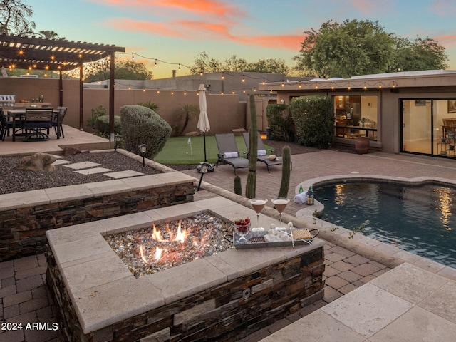 pool at dusk with a pergola, a fire pit, and a patio