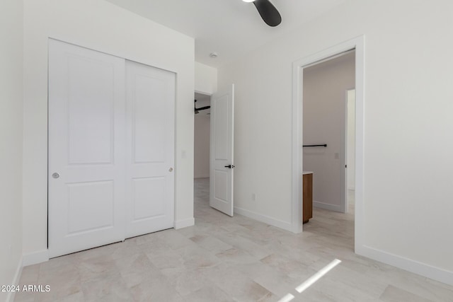 unfurnished bedroom featuring ceiling fan and a closet