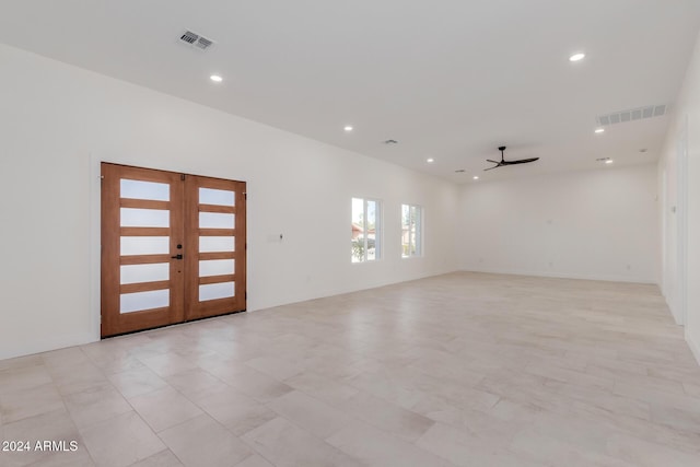 empty room featuring ceiling fan and french doors