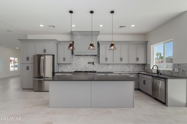 kitchen with pendant lighting, a center island, stainless steel appliances, and sink