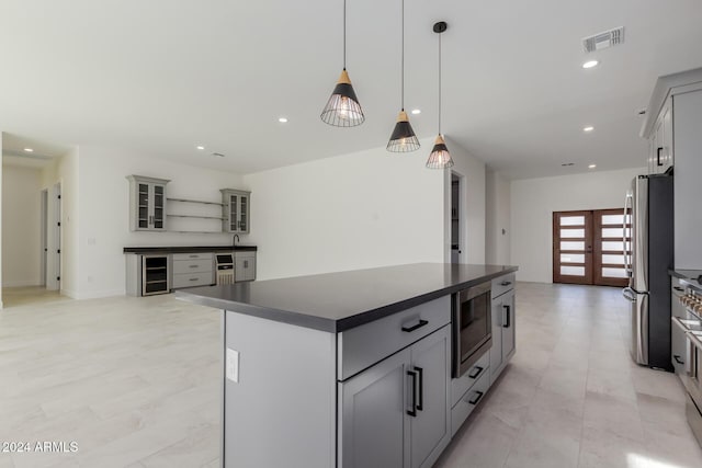 kitchen featuring gray cabinetry, wine cooler, decorative light fixtures, a kitchen island, and stainless steel appliances