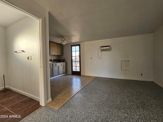 tiled empty room with ceiling fan and a wall unit AC
