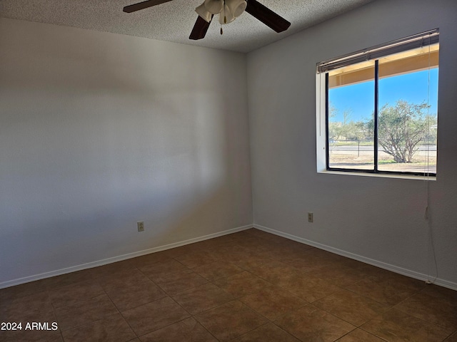 tiled empty room featuring a textured ceiling and ceiling fan