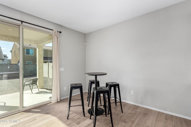 dining space featuring baseboards, wood finish floors, and a healthy amount of sunlight