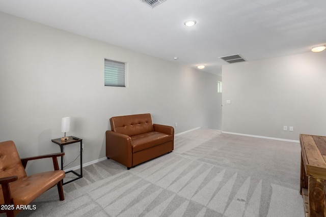 living area featuring light carpet, visible vents, and baseboards